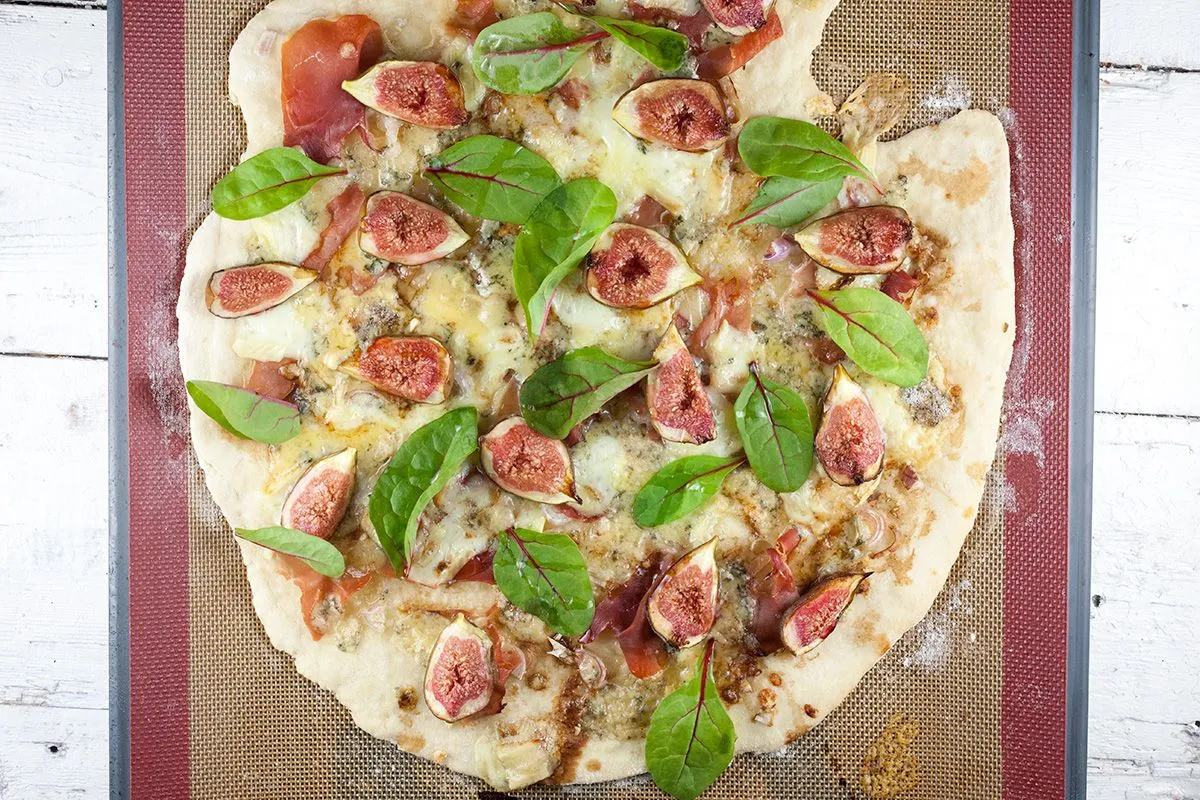 Fig-prosciutto pizza with purple baby spinach