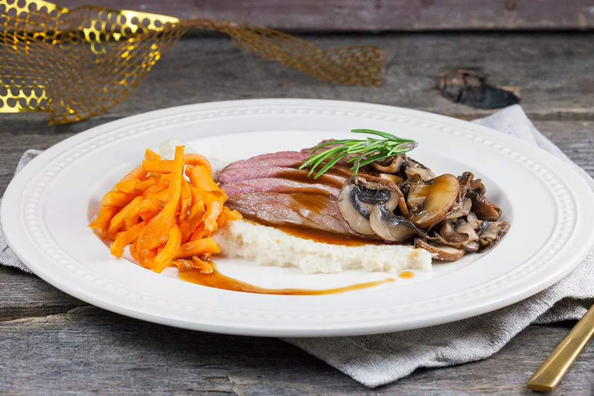 Venison steak with roasted cauliflower puree and sweet potato fries
