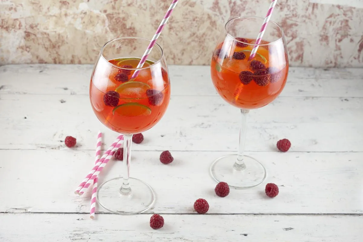 Aperol cocktail with lime and raspberries