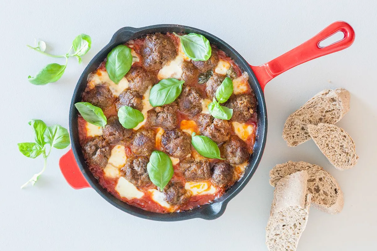 Oven baked meatballs in tomato sauce and mozzarella